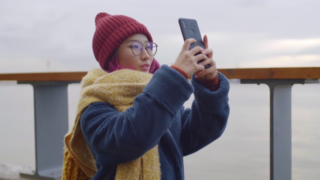 亚洲女游客在河边用手机拍摄全景照片视频素材