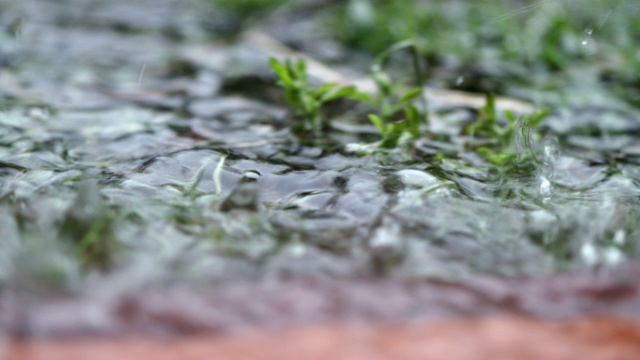 倾盆大雨以慢镜头落到地面，形成巨大的水滴视频素材