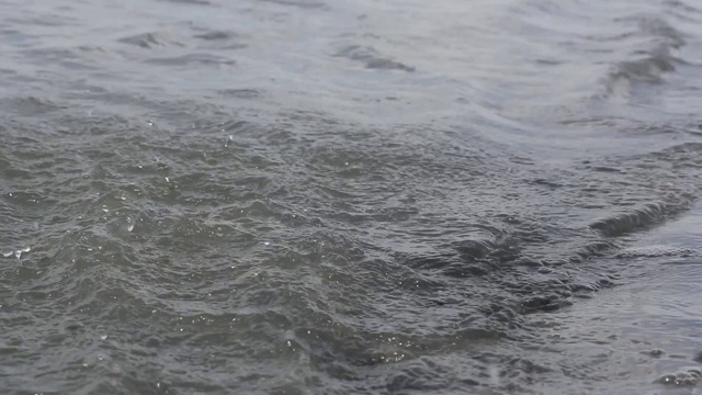 一个女游客的近距离接触波浪的河水表面和溅水珠，而享受一个休闲的船乘坐视频素材