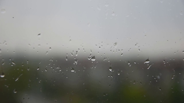 雨敲打着窗户玻璃，暴雨，雨季，悲伤，放松。忧郁，在雨天呆在屋里视频素材