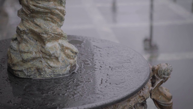 雨天花岗岩基座上的儿童抱鱼石装饰雕塑视频素材