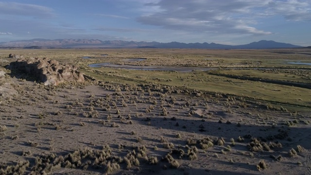 在安第斯山脉的河流和岩石景观中，一个皮卡露营者的航拍视频素材