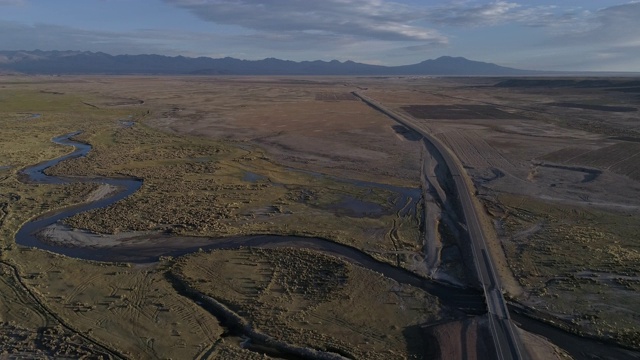 安第斯山脉中，一条穿过河流的道路和岩石景观的航拍视频素材