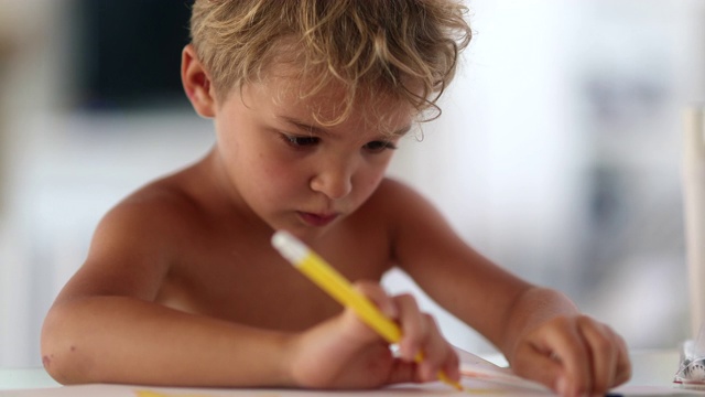 年幼的男孩，蹒跚学步的婴儿在纸上用黄色的钢笔画画。流中的艺术儿童视频素材