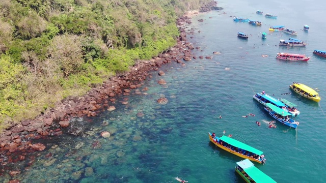 在印度南果阿海滩游泳的人周围漂浮在海洋上的船，鸟瞰图视频素材