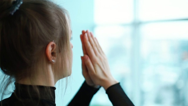 宁静的年轻女子沉思手在一起的背影视频素材