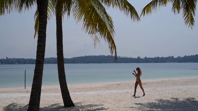 性感的女人在比基尼快乐的微笑走在夏季旅游度假的热带海滩上。泰国的Koh Mak岛视频素材