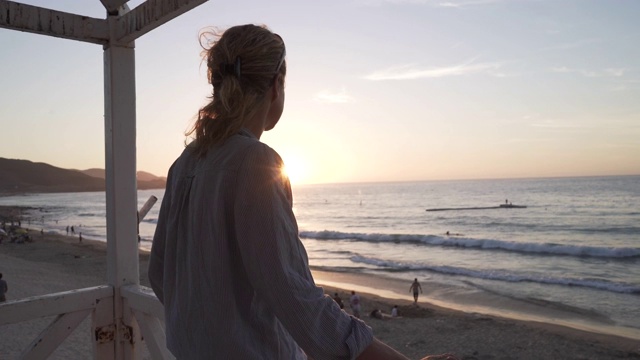 在海滩上日落的女人的特写视频素材