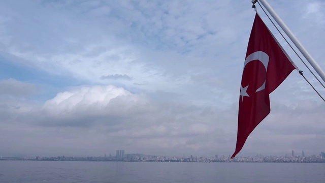 船上挂着土耳其国旗，美丽的云景，飞翔的海鸥和伊斯坦布尔城市的天际线视频素材