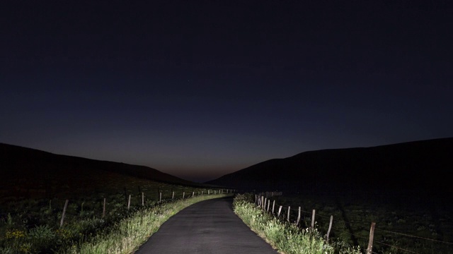 POV夜间到白天的Hyperlapse T/L行驶在道路上，沿着草地视频素材