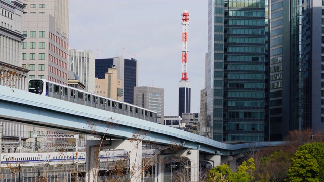 2018年1月18日，日本东京港区新桥区和盐堂区附近的高层办公建筑之间的高架铁路“Yurikamome”(东京滨水新运输滨水线)运行。视频素材