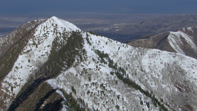 鸟瞰白雪皑皑的瓦萨奇山与盐湖城，犹他州的远景。视频素材