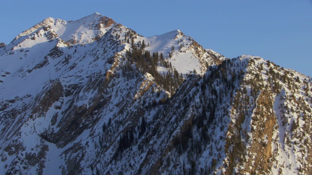 双峰和白雪皑皑的瓦萨奇山脉在日出时天空的鸟瞰图，盐湖城，美国犹他州。视频素材