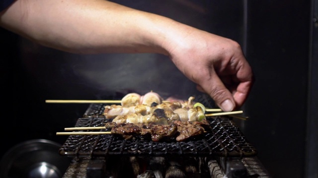 东京居酒屋日式酒吧厨师烹饪的慢镜头。日本的食物视频素材