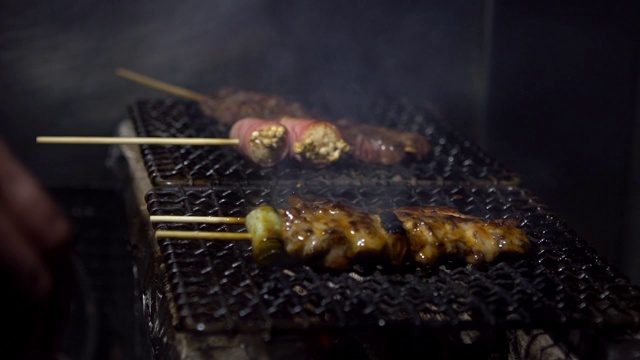 小吃摊上的烤鸡肉串的慢镜头。串东京视频素材