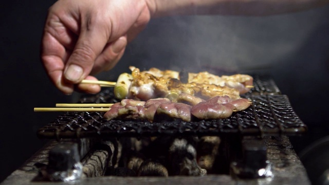 东京居酒屋日式酒吧厨师烹饪的慢镜头。日本的食物视频素材