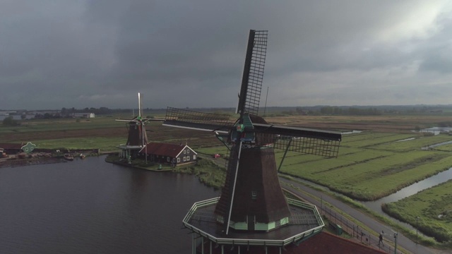 在荷兰北部的清洁能源旅游景点Zaanse Schans，当我们转向盘旋在空中的传统历史荷兰风车叶片时，海鸥经过视频素材