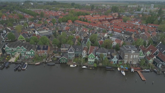 在荷兰北部的Zaanse Schans，沿着绿色的、历史悠久的荷兰传统滨河房屋飞行视频素材