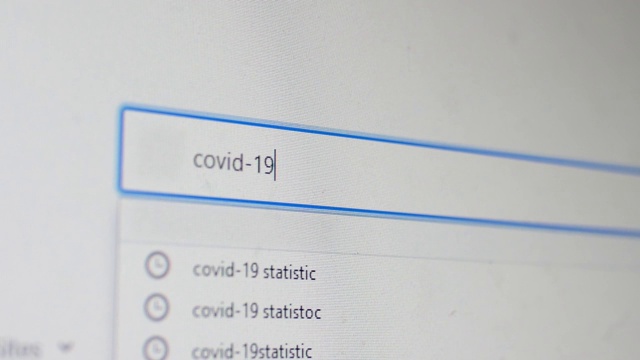 电脑屏幕上的类型想要在浏览器上查找Covid-19统计数据视频素材