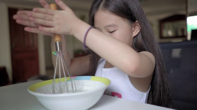 可爱的亚洲小女孩在家做饭视频素材