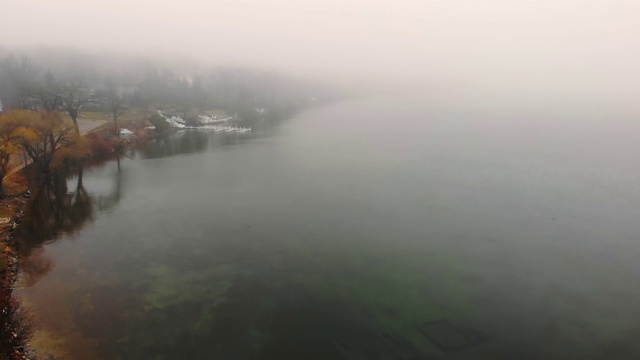 在大雾多云的天气中飞过湖面。雾天的湖堤。视频素材