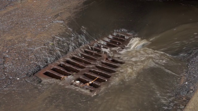 下雨时，水通过铁网排入下水道视频素材