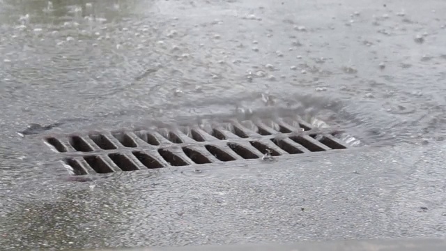 下雨时，水通过铁网排入下水道视频素材