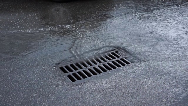 下雨时，水通过铁网排入下水道视频素材