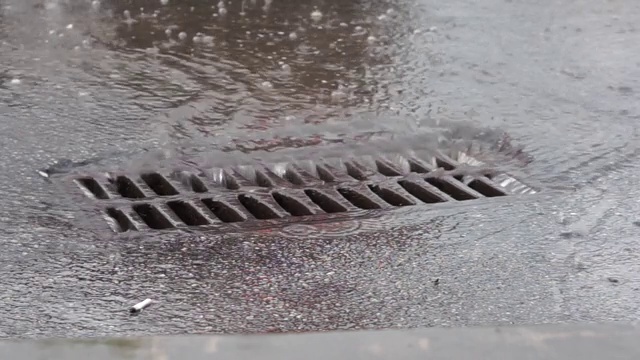 下雨时，水通过铁网排入下水道视频素材