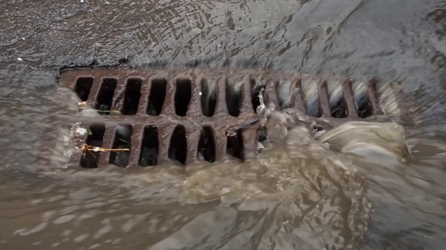 下雨时，水通过铁网排入下水道视频素材