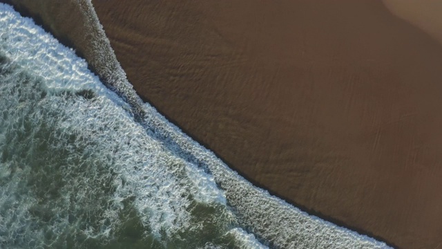 旋转鸟瞰空旷的海滩和海浪视频素材