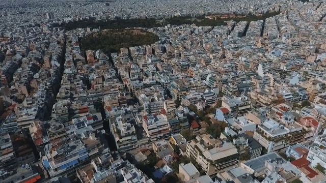 无人机拍摄的城市街区和屋顶与山脉的背景雅典视频下载