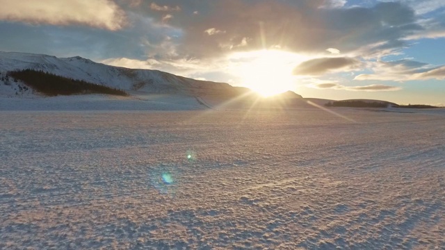 航拍令人惊叹的冰岛在冬天白雪皑皑的山脉在日出视频下载