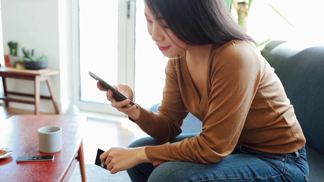 年轻女子用智能手机网购视频素材