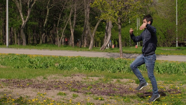 一个滑稽的男人拿着花跑过公园视频素材