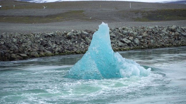 在冰岛的Jokulsarlon冰川泻湖，一个巨大的正在融化的冰块漂向海洋视频素材