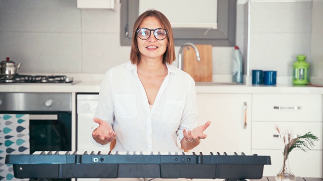 年轻的成年女性音乐教师为在线课程录制视频。视频素材