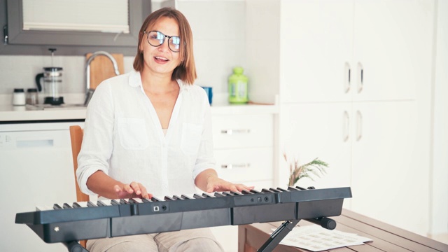 年轻的成年女性音乐教师为在线课程录制视频。视频素材