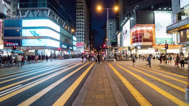 在香港孟角，一群行人和交通车辆在人行横道上行走视频素材