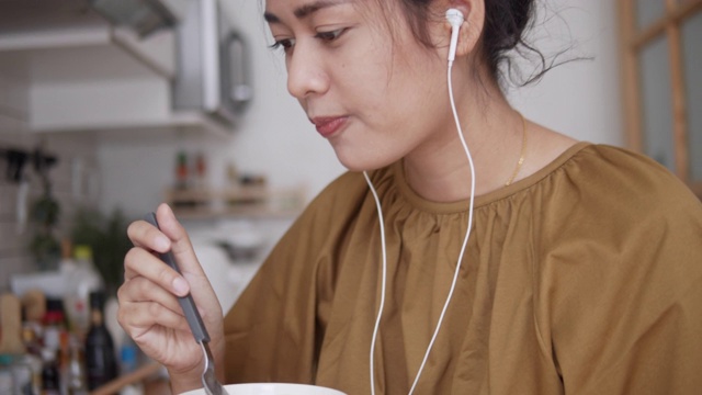 亚洲女性，作为自由职业者在家工作，进行电话会议，在厨房里讨论项目。视频素材