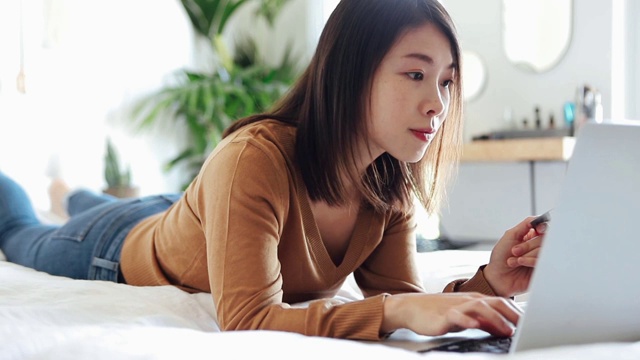 年轻女子用笔记本电脑和信用卡在网上购物视频素材