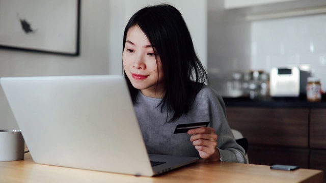 年轻女子用笔记本电脑和信用卡在网上购物视频素材