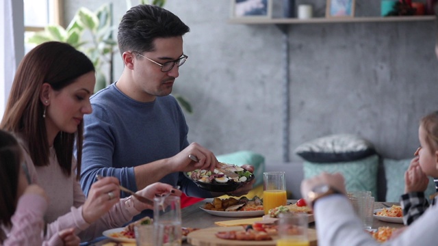 两个家庭在家里一起吃午饭视频素材