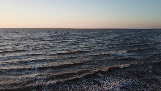 鸟瞰海岸和海浪与日落。无人驾驶飞机。视频下载