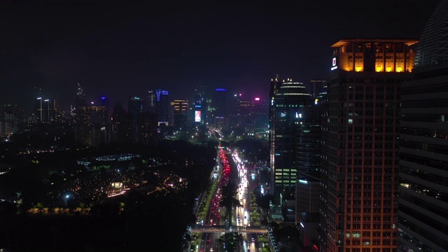 雅加达市夜间照明市中心繁忙的交通街道大道空中全景4k印尼视频素材