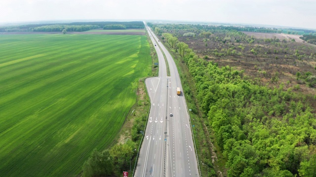 鸟瞰图绿色田野之间的公路在春天。视频素材