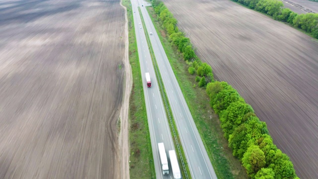 鸟瞰图绿色田野之间的公路在春天。视频素材