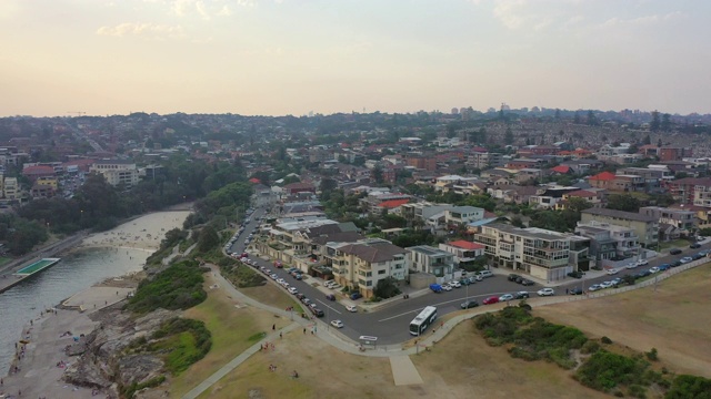 空中拍摄的人在海滩上的建筑物对天空，无人机飞向城市景观-悉尼，澳大利亚视频素材