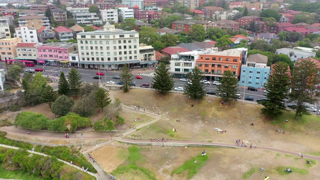 空中拍摄的人和车辆在城市建筑，无人机向后飞在海滩上-悉尼，澳大利亚视频素材