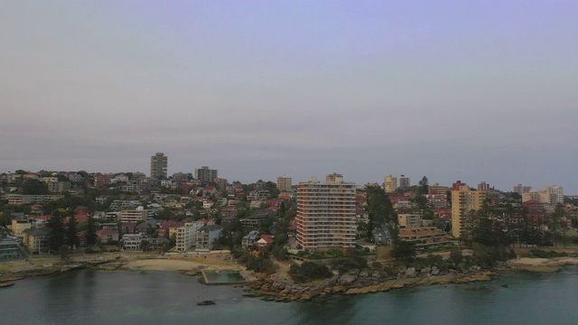 空中平移拍摄的城市建筑在日落的天空，无人机飞越海岸线-悉尼，澳大利亚视频素材